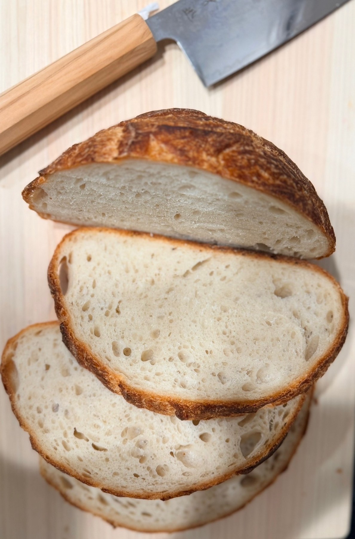 Fresh bread sliced on a wooden cutting board