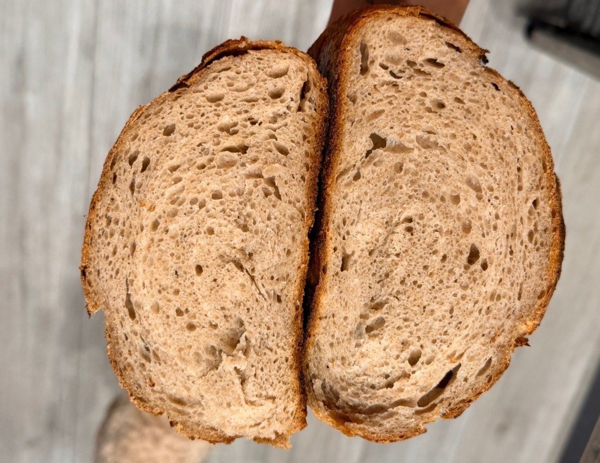 A freshly baked loaf cut in half to reveal its crumb